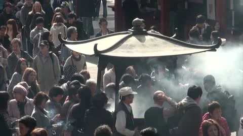 Crowds gather around urn that burns incense in Tokyo, Japan Stock Footage