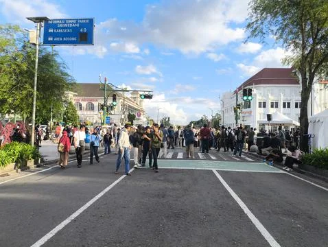 Crowds gather at intersection with traffic lights Foto stock