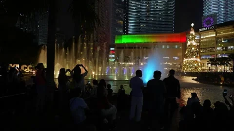 Crowds gather at KLCC Esplanade, captivated by the Symphony Lake Fountain Show Video stock 318092483