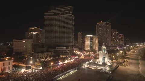 Crowds gather for nighttime celebration at the beachside promenade Video stock 307725962