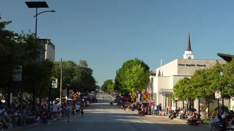 Crowds line a street during a parade near First Baptist Church Video stock 340940764