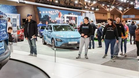 Crowds looking at new car models at Auto show. Hyundai Kona electric car on d Foto stock