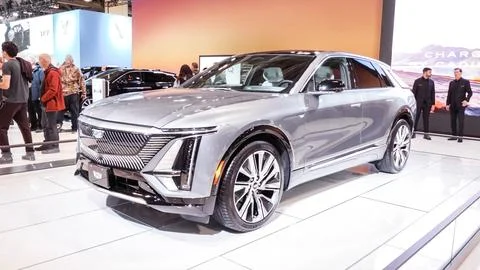 Crowds looking at new car models at Auto show. Cadillac car on display. Natio Stock Photos