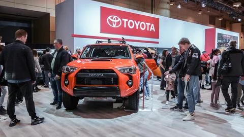 Crowds looking at new car models at Auto show. Toyota car on display. Nationa Stock Photos