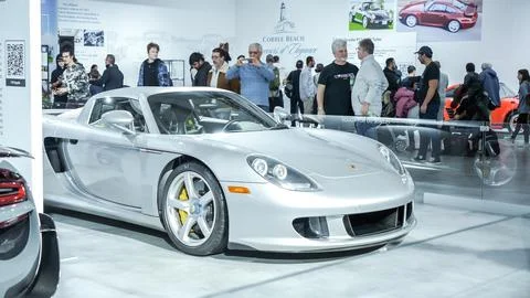 Crowds looking at new car models at Auto show. Porsche Spyder car on display. Stock Photos