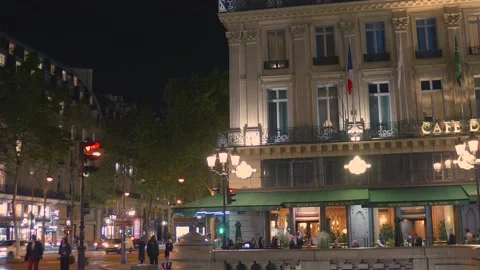 Crowds Passing Historic Parisian Café and City Street Illuminated at Night in Stock Footage 336984733