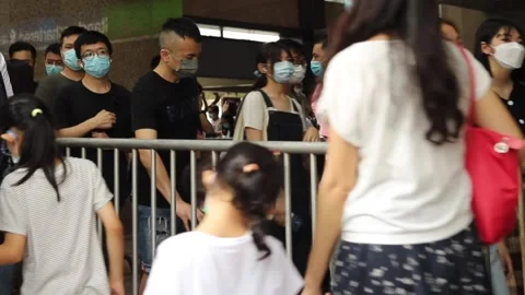 Crowds of People with face masks wait in queue to buy books in Hon Stock Footage 158096090