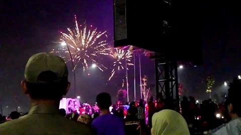 Crowds of people gather to view the fireworks during the New Year's Eve festival Vídeos de archivo 304555321