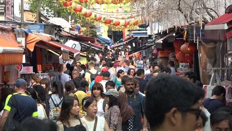 Crowds of people visit a popular shopping street in Chinatown Singapore Stock Footage