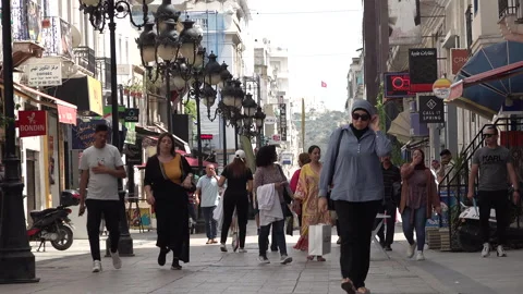 Crowds of people walk through popular shopping street in central Tunis Tunisia Stock Footage 328633292