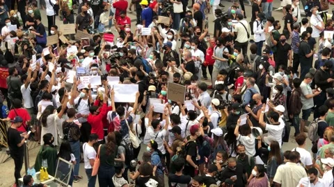 Crowds of Protesters hold up Signs outside Bangkok Art and Culture Centre Stock Footage 148236173