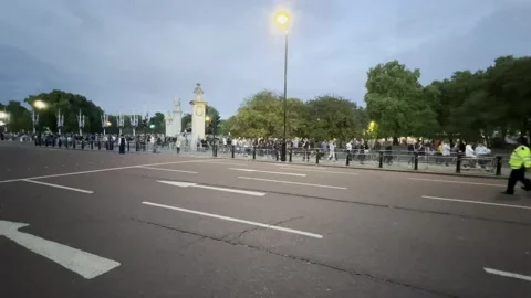 CROWDS QUEUE AT BUCKINGHAM PALACE PAYING RESPECTS TO QUEEN ELIZABETH II Stock Footage 208958089