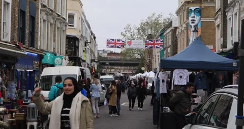 Crowds strolling through Portobello Road street market in London Stock Footage 321033938