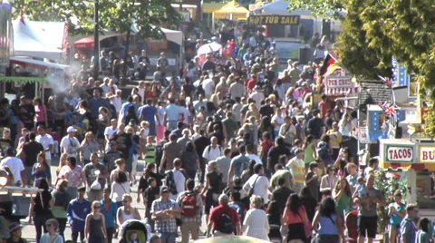 Crowds at summer fair, slo motion walking up midway.  Daytime sunny. Stock Footage 27553443