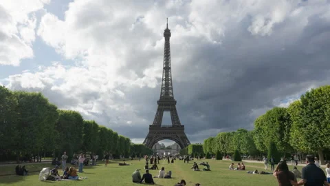 Crowds of tourists relax on Champ de Mars lawn near Eiffel Tower monument Stock Footage 336725149