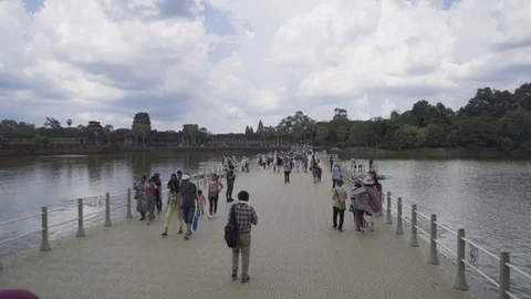 Crowds of tourists use the temporary floating causeway to cross the moat Stock Footage 108709981
