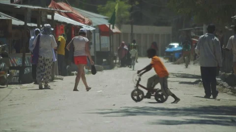Crowds walk down the streets shopping at village beach town in Nungwi, Zanzibar. Stock Footage 86648103