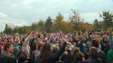  Crowds of young men throws up in the air powder paint of different colours. Video stock 32839928