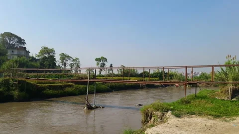Crows, birds flying around old iron bridge made by local people in a river Stock Footage 248734158