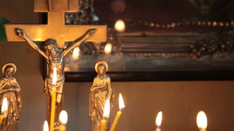 Crucifix and burning candles Stock Footage
