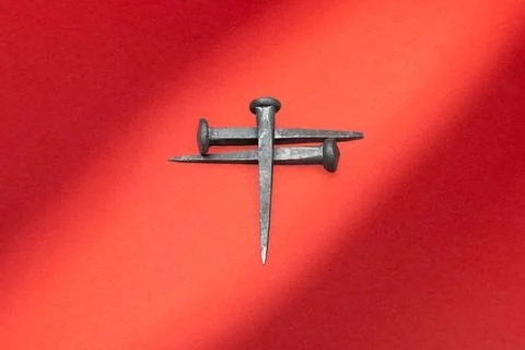 Crucifixion nails with dramatic lighting on red background Fotos Stock