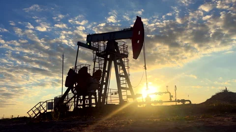 Crude pump jack working on sunrise in oil field. Oil Pump Jack Stock Footage 317757946