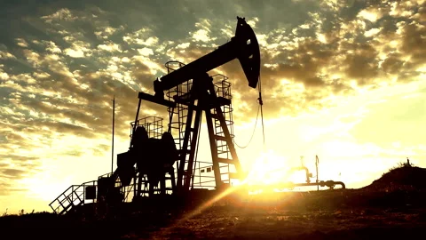 Crude pump jack working on sunrise in oil field. Oil Pump Jack Stock Footage 317759501