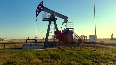 Crude pump jack working on sunrise in oil field. Oil Pump Jack Stock Footage 321056435