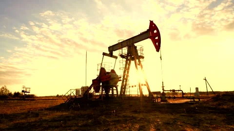Crude pump jack working on sunrise in oil field. Oil Pump Jack Stock Footage 321095299