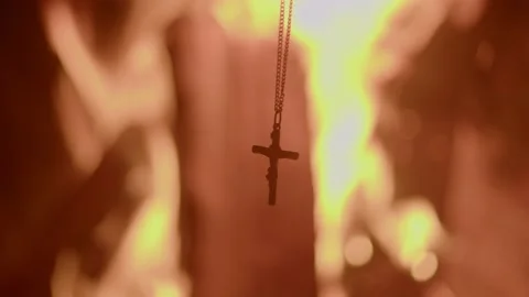 Cruicifix in front of  a fire Stock Footage 232961593