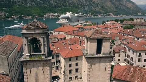 Cruise ship docked in Kotor. Cinematic aerial footage over the old town Stock Footage