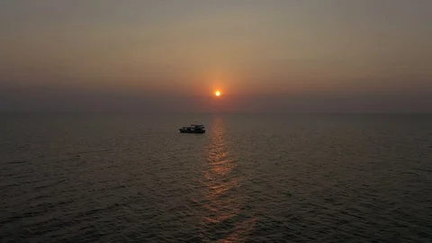 Cruise ship floating on ocean waves in sea water in sunset with red sun above h Stock Footage 124326415