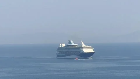 Cruise ship navigating calm waters with tender boat alongside Stock Footage 313433535