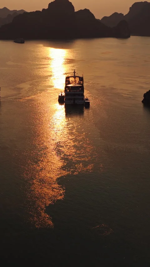 Cruise Ship Sailing Through Ha Long Bay With Reflection Of Golden Sunlight In Stock Footage 342723321