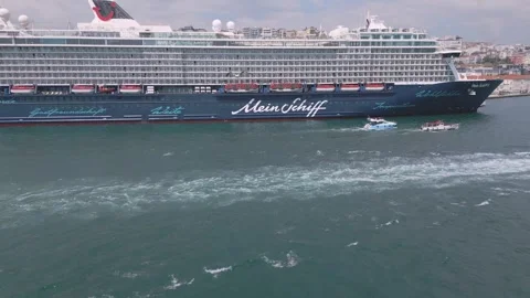 Cruise ship sails through scenic waters near a bustling cityscape Vídeos de archivo 310153473
