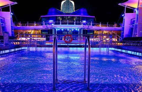 Cruise ship swimming pool at night on the top deck with scenic views Stock Photos