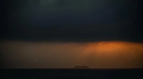 Cruise ship under a dramatic sky with sunlight filtering through the clouds.. Foto stock