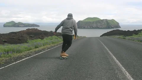Cruising on a longboard down road 스톡 동영상 257981000