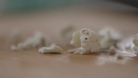 Crumbling cheese onto chopping board Stock Footage 194478612