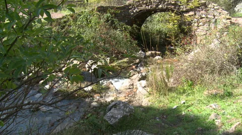 Crumbling stone bridge over mountain stream, tilt up Stock Footage 56128520
