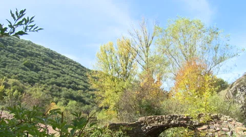 Crumbling stone bridge over mountain stream, tilt down Stock Footage 56129960