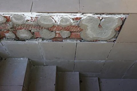 Crumbling wall covered with ceramic tiles, the result of poor quality work 스톡 사진