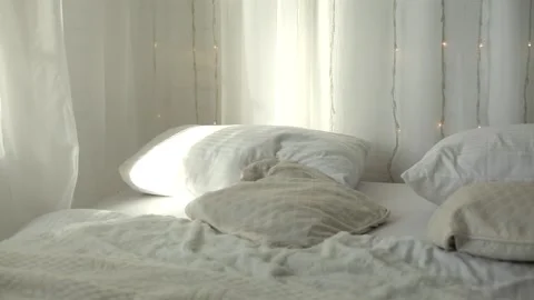 Crumpled bedding on the bed in the room in the early sunny morning. Stock Footage 166702398