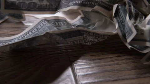 Crumpled bills falling from above,close-UPS of hundred-dollar on table Stock Footage 128959098