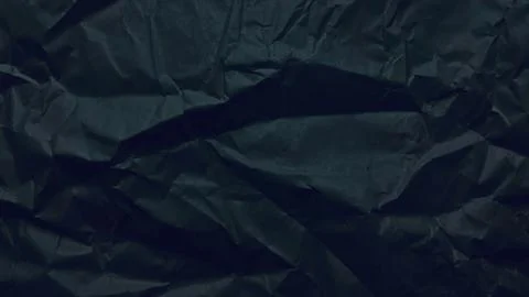 Crumpled black paper texture creates dynamic shadows across a minimalist or.. Stock Photos