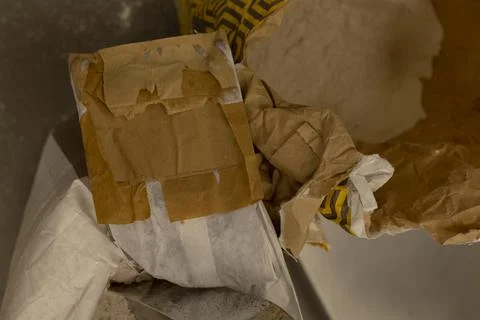Crumpled brown paper packaging with torn white wrapping inside cardboard box Stock Photos