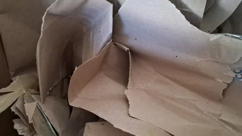 Crumpled brown paper sheets moving inside a shipping box video footage Stock Footage 337897004
