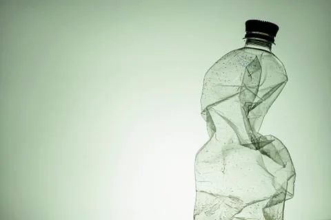 Crumpled clear empty plastic bottle with lid Foto stock