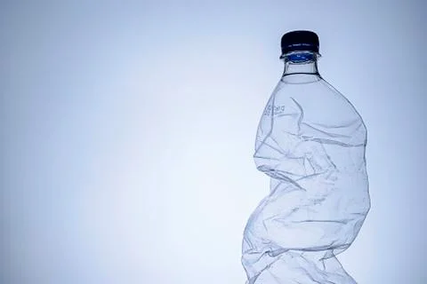 Crumpled clear empty plastic bottle with lid Stock Photos