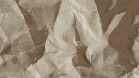 Crumpled craft paper close-up. Recycle brown sheet texture, old beige surface Stock Footage